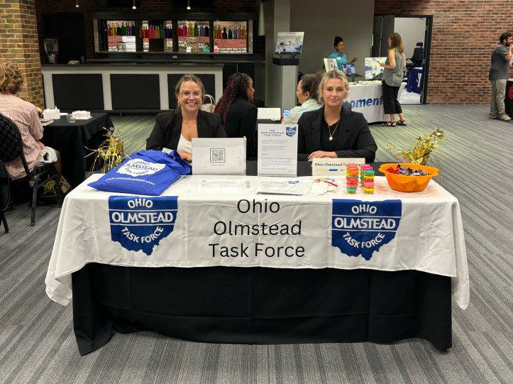 Picture of OOTF members seated at conference table with banner and swag.
