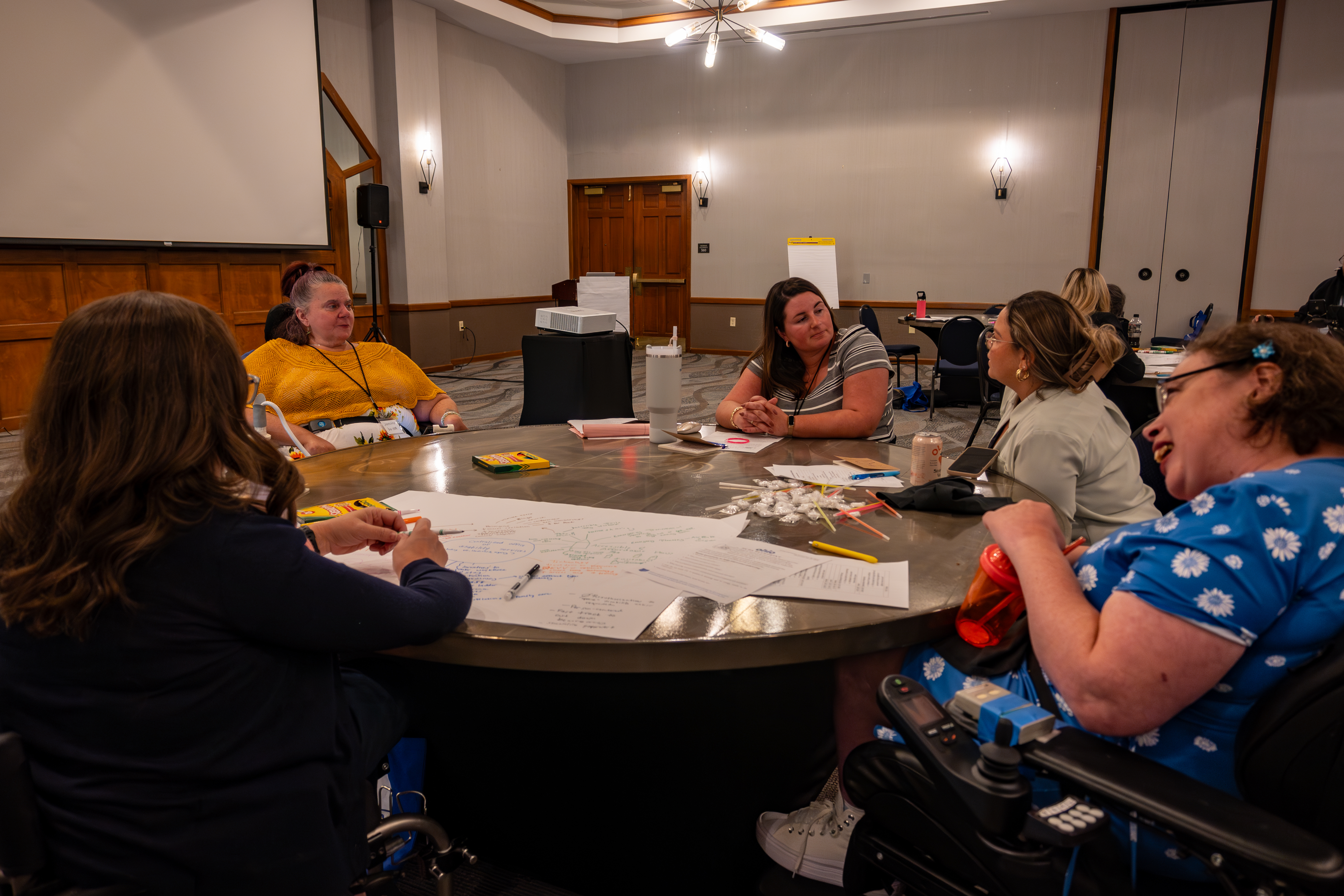 OOTF advocates discuss action plans around a table at retreat.