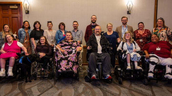 OOTF Advocates pose for a group photo against a wall indoors